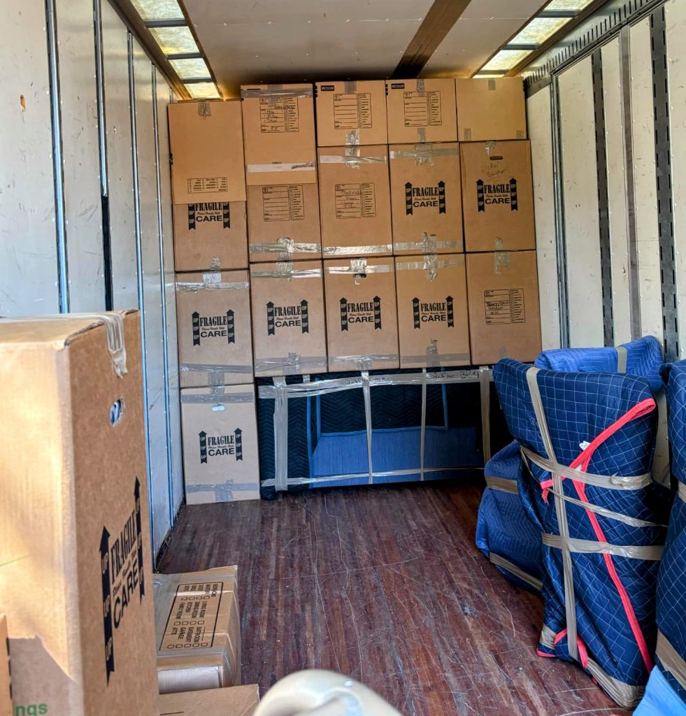 Cardboard moving boxes stacked in a room, showing why climate controlled storage Southwest Florida options save valuables from heat and humidity.